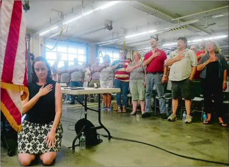  ?? SARAH GORDON/THE DAY ?? Selectwoma­n Melissa Schlag kneels for the Pledge of Allegiance during a meeting Monday at the Haddam firehouse.