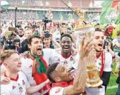  ?? IVAN VODOPYANOV/AFP ?? Lokomotiv Moscow’s players celebrate with the trophy as they claimed their third ever Russian league title following the match against Zenit St Petersburg at Moscow’s RZhD Arena on Saturday.