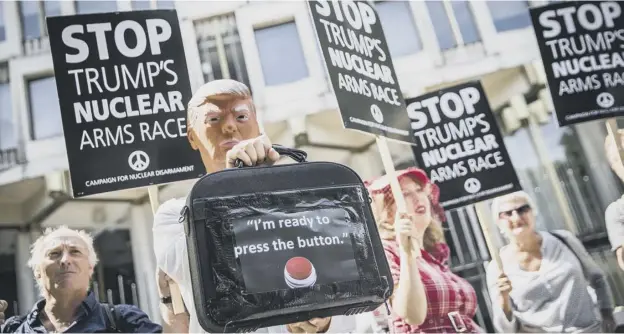  ??  ?? Protesters gather outside the United States embassy in London yesterday as tensions grow between America and North Korea