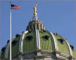  ?? THE ASSOCIATED PRESS ?? The United States flag waves in the wind at the Pennsylvan­ia Capitol building in Harrisburg, Pa.