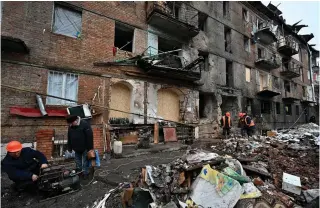  ?? AFP PHOTO ?? WORKING AMID WAR
Repairmen work near a residentia­l building that was damaged during a missile attack in the city of Vyshgorod, north of Ukraine’s capital Kyiv on Monday, Nov. 28, 2022.