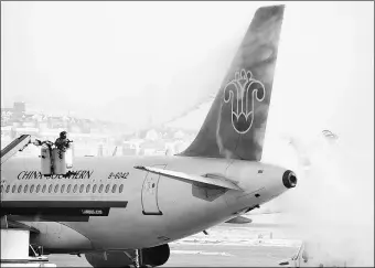  ?? LIU DEBIN / FOR CHINA DAILY ?? A worker removes ice and snow from a China Southern Airlines Co Ltd aircraft at an airport in Dalian, Liaoning province.