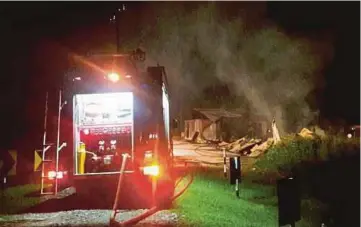  ??  ?? ANGGOTA bomba memadam kebakaran rumah setinggan berhampira­n tapak pelupusan sampah, Batu 1, Kuala Baram.