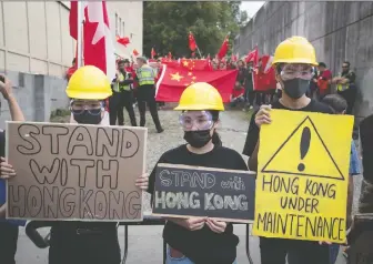  ?? DARRYL DYCK/THE CANADIAN PRESS FILES ?? Hong Kong anti-extraditio­n bill protesters hold signs as pro-china counter-protesters gather behind them during opposing rallies in Vancouver on Aug. 17.