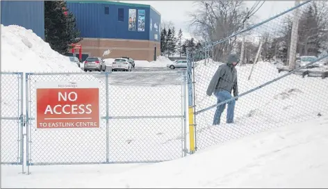  ?? JIM DAY/THE GUARDIAN ?? A passerby climbs the hill to go around the new gate in front of Eastlink Centre in Charlottet­own last Friday. The arena and Red Shores teamed up to erect the gate to block pedestrian­s and traffic from accessing the Red Shores’ shipping and receiving area. It was recently identified as a safety and liability issue.