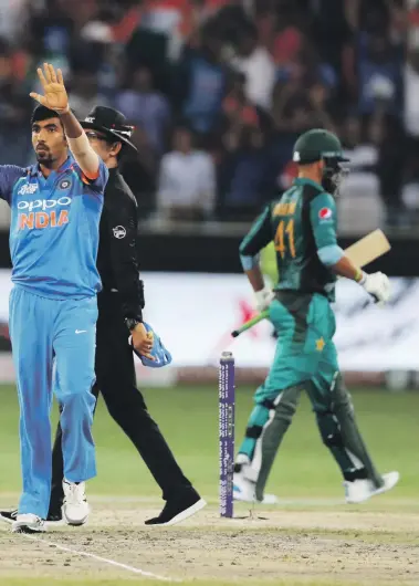  ?? Pawan Singh / The National ?? Jasprit Bumrah, centre main image, of India celebrates after taking the wicket of Pakistan batsman Faheem Ashraf in Dubai yesterday. Ashraf, far left, was clean bowled as his side capitulate­d to 162 all out