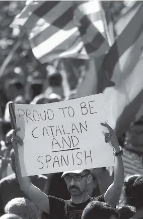  ?? AP ?? A man holds up a sign during a march in downtown Barcelona, Spain, to protest the Catalan government’s push for secession from the rest of Spain, yesterday. Sunday’s rally comes a week after separatist leaders of the Catalan government held a...