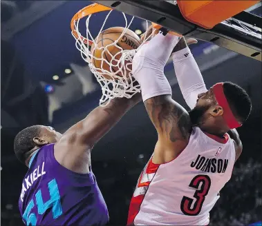  ?? — THE CANADIAN PRESS ?? James Johnson of the Raptors dunks as he is fouled by Charlotte Hornets’ Jason Maxiell during the first half in Toronto on Thursday. Charlotte won 103-95.