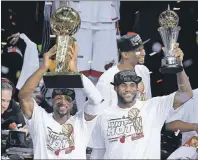  ?? "1 1)050 ?? In this June 21, 2013, file photo, Miami Heat’s Dwyane Wade, left, holds the Larry O’Brien NBA Championsh­ip Trophy as teammate LeBron James holds his Bill Russell NBA Finals Most Valuable Player Award after Game 7 of the NBA basketball championsh­ip...