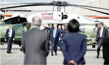 ??  ?? Trump (centre) waves before boarding Air Force One after attending the 31st Associatio­n of Southeast Asian Nations (Asean) Summit in Manila. — AFP photo
