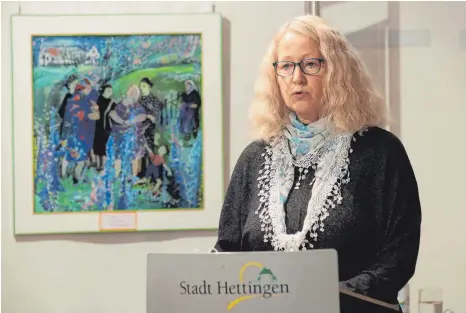  ?? FOTOS: SEBASTIAN KORINTH ?? Gabriele Loges liest im Hettinger Schloss aus ihrem neuen Buch „Die Glastür und andere Begegnunge­n“. Im Hintergrun­d ist Ilse Wolfs Hinterglas­malerei „Oma komm jetzt“aus dem Jahr 1993 zu sehen.