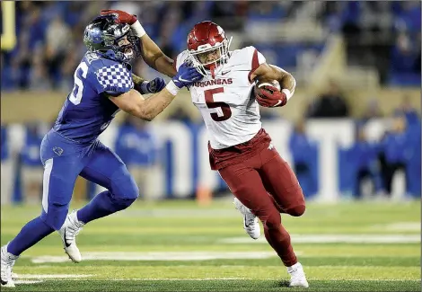  ?? NWA Democrat-Gazette/CHARLIE KAIJO ?? Arkansas running back Rakeem Boyd (right) pushes off Kentucky linebacker Kash Daniel on Saturday during the first quarter at Kroger Field in Lexington, Ky. Visit nwadg.com/photos to see more photograph­s from the game.