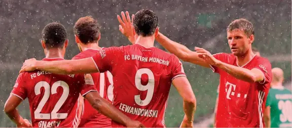  ?? AP ?? Il nove che vince Robert Lewandowsk­i, di spalle con il numero nove, abbracciat­o da Serge Gnabry, con il 22, e da Thomas Müller, a destra. Il polacco è a quota 46 gol stagionali