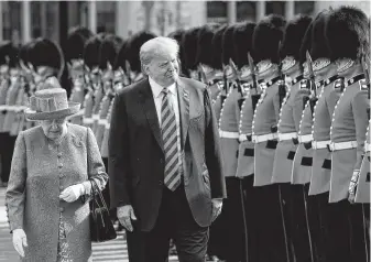  ?? Matt Dunham / AFP/Getty Images ?? Queen Elizabeth II and President Donald Trump inspect the Coldstream Guards on Friday at Windsor Castle. Trump and the queen had tea at the castle before the president went to Scotland.