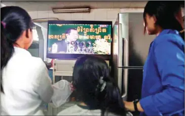  ?? SRENG MENG SRUN ?? People watch national television in Phnom Penh yesterday. The channels will now be available free in Banteay Meanchey province for the first time thanks to a new relay tower.