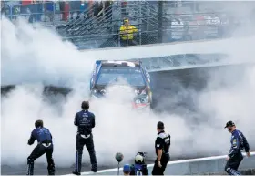  ?? Brian Lawdermilk / Getty Images ?? Kasey Kahne celebrates with a burnout after winning the Brickyard 400. He later was treated for dehydratio­n at the infield medical center.