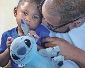  ?? DAMON HIGGINS/PALM BEACH DAILY NEWS ?? Tiffany Pinkney’s son Kendric, 2, and Pinkney’s partner and the father of her children, Marquis Lacy, share a moment in the family’s Lake Worth Beach apartment.