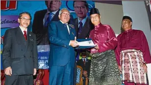  ?? Service rewarded: ?? Mahdzir (second from left) giving the Tokoh Guru Negeri Kelantan 2017 Award to Ghazali. — Bernama