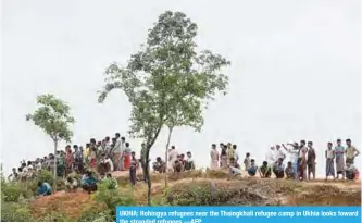  ??  ?? UKHIA: Rohingya refugees near the Thaingkhal­i refugee camp in Ukhia looks toward the stranded refugees.—AFP