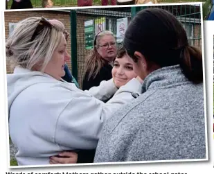  ?? ?? Words of comfort: Mothers gather outside the school gates