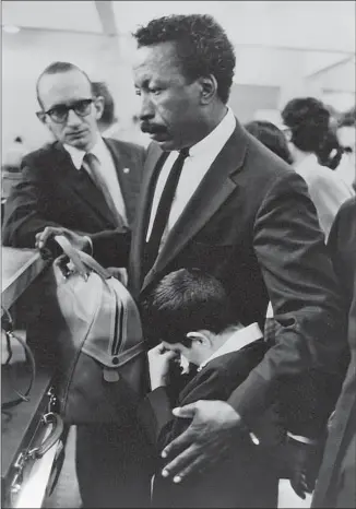  ?? Estate of Paulo Muniz / IMS ?? A YOUNG Da Silva clings to Parks on July 5, 1961, as they readied to board a plane for the U.S. where Da Silva would receive medical care. The two retained a bond until Parks’ death in 2006.