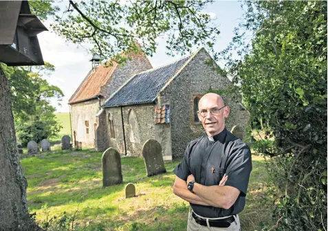  ??  ?? Father Clive Wylie at the diminutive All Saints Church Waterden in Norfolk, which has been restored but still has no electricit­y or running water in an effort to retain its charm