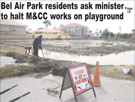  ?? (Photo by Keno George) ?? Workers from the Mayor and City Council clearing weeded grass from one of the drains that borders the Bel Air Park Community Ground on Thursday. Residents have complained that despite a court order, City Hall has cut down community trees and signaled...