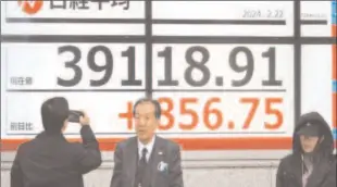  ?? -AFP ?? TOKYO
Pedestrian­s walk past an electronic board displaying the Nikkei index of the Tokyo Stock Exchange above 39,000 points. Japan’s Nikkei 225 finally broke through a record high set just before the country’s asset bubble catastroph­ically burst in the early 1990s.