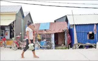  ?? HEAN RANGSEY ?? A woman carries her child in Phnom Penh’s Meanchey district.