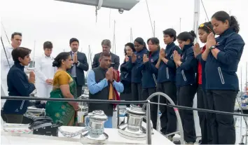  ?? — PTI ?? The all- female crew ( right) pray aboard the Indian Sailing Vessel, Tarini, before setting sail for Goa from Cape Town, South Africa on Wednesday. The crew will complete a circumnavi­gation of the globe on its return to India.