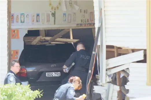  ?? — Gambar Reuters ?? MALANG: Pegawai perkhidmat­an kecemasan dan polis memeriksa sebuah kenderaan yang merempuh bilik kelas sebuah sekolah rendah di Greenacre, pinggir Sydney semalam.