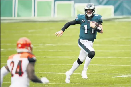  ?? CHRIS SZAGOLA — THE ASSOCIATED PRESS ?? Eagles quarterbac­k Carson Wentz scrambles during the first half Sunday against the Cincinnati Bengals. The Bengals’ defense has the struggling Birds quarterbac­k on the run much of the game.