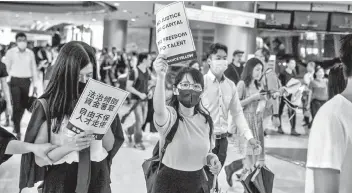  ?? — AFP file photo ?? People from the finance community march through a shopping mall during a protest against a controvers­ial extraditio­n bill in Hong Kong.