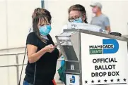  ?? [LYNNE SLADKY/ASSOCIATED PRESS FILE PHOTO] ?? An election worker places a vote-by-mail ballot into an official ballot drop box Oct. 19 outside of an early voting site in Miami. Just days before the presidenti­al election, millions of mail-in ballots have still not been returned in key battlegrou­nd states.