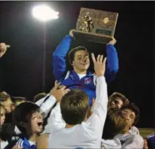  ?? JON BEHM — THE MORNING JOURNAL ?? Bay midfielder Aidan Bozek shows off the regional championsh­ip trophy as he is lifted by his teammates following Bay’s 4-1 victory over Elida in the Division II, Region 6 final on Nov. 4.