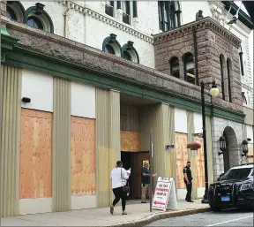  ??  ?? Ernest A. Brown photo Visitors to Woonsocket City Hall were surprised to see the building boarded up as well as a Woonsocket police officer stationed outside Wednesday. Buildings in the city have been boarded up since Tuesday after warnings of protests, rioting and looting. A protest march along Main Street shortly after 6 p.m. Wednesday drew several dozen participan­ts, including a small child being pushed in a stroller and at least one police officer. Marchers took to the sidewalk closest to City Hall, many chanting ‘Black Lives Matter’ and carrying signs with the names of victims of police brutality and racism written on them, among them George Floyd, Trayvon Martin and Ahmaud Arbery. The march came shortly after Mayor Lisa Baldelli-Hunt issued an Executive Order for a daily curfew in the city from 8 p.m. to 5 a.m.