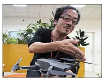  ?? AP/EUGENE HOSHIKO ?? In this photo taken earlier this month, Atsushi Taguchi, a “drone grapher,” as those specializi­ng in drone video are called, who teaches at Tokyo film school Digital Hollywood, speaks during an interview with the Associated Press in Tokyo.