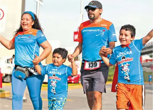  ??  ?? Diego y Carlos Henríquez junto a sus padres celebran emocionado­s luego de alcanzar la meta en la carrera de Australian.