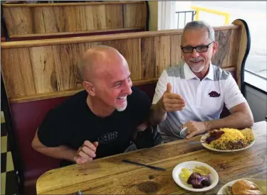  ?? The Sentinel-Record/Grace Brown ?? OLD FRIENDS: Roger Scott, right, a popular morning DJ with 103.7 The Buzz, shares a laugh with his old friend, Scott McClard, at McClard’s restaurant Tuesday as Scott discusses his role in the recently released feature film, “Antiquitie­s.” The Arkansas set film has made the rounds of film festivals across the country and is now available to buy or rent.