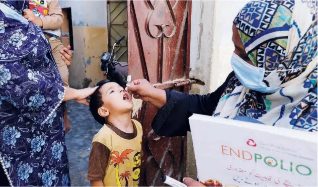  ?? Associated Press ?? ↑
A health worker gives a polio vaccine to a child in Karachi on Monday.