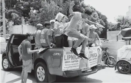  ?? (PNA) ?? MANILA. A teener jumps off a vehicle to distribute campaign materials during a sortie for the May 14 Barangay and Sanggunian­g Kabataan elections at the National Irrigation Administra­tion (NIA) Road in Quezon City on Tuesday, May 8, 2018.