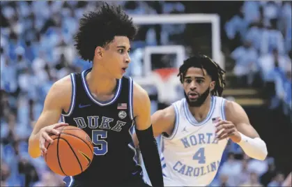  ?? AP PHOTO/JACOB KUPFERMAN ?? Duke guard Tyrese Proctor (5) is defended by North Carolina guard R.J. Davis (4) during the first half of an NCAA college basketball game on Saturday in Chapel Hill, N.C.