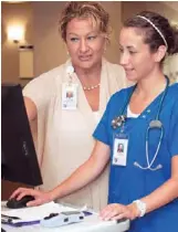  ??  ?? Julie Michaelson, left, a nurse and a clinical consulting analyst in Hartford Hospital’s IT department, reviews the delirium documentat­ion system with Michelle Kangos, a staff nurse in the oncology unit. Michaelson helped design the system.