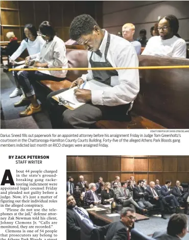  ?? STAFF PHOTOS BY DOUG STRICKLAND ?? Darius Sneed fills out paperwork for an appointed attorney before his arraignmen­t Friday in Judge Tom Greenholtz’s courtroom in the Chattanoog­a-Hamilton County Courts Building. Forty-five of the alleged Athens Park Bloods gang members indicted last...