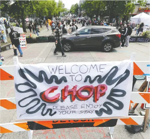  ?? TED S. WARREN / AP PHOTO ?? A sign reads “Welcome to CHOP” inside what has been named the Capitol Hill Occupied Protest zone in Seattle. Protesters calling for police reform have taken over several blocks near downtown Seattle after officers withdrew from a police station in the area. Columnist Rex Murphy worries about the precedent the occupation is setting.