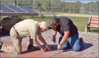  ?? BOB KEELER — MEDIANEWS GROUP ?? Pat McNulty, left, and Patrick Helverson remove a brick from the walkway in James Memorial Park in West Rockhill to make room for the new brick honoring McNulty’s military service.