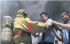  ??  ?? APOYO. Bomberos usaron sus trajes especiales para no resultar quemados.