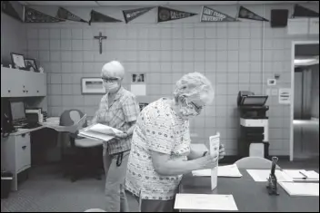  ?? ASSOCIATED PRESS ?? Guidance secretary Marge Berckmille­r (left) and Sister Bridget Reilly, director of guidance, prepare student transcript­s to send to other schools Monday after the closure of Quigley Catholic High School in Baden, Pa. The staff learned of the closure May 29 via videoconfe­rence.