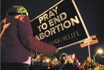  ?? Timothy Tai / Associated Press 2016 ?? Protesters hold antiaborti­on signs in 2016 outside the Planned Parenthood Columbia Health Center in Columbia, Mo. The clinic canceled all abortions due to a new state requiremen­t.