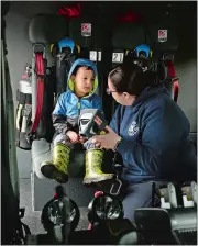  ?? DANA JENSEN/THE DAY ?? Kingston Goula, 3, of Niantic, listens while EMT Nicole Betulia shows him a thermal imaging camera Saturday while sitting in the back of the Flanders Fire Department tower ladder truck in Niantic.